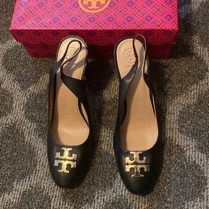 Tori Burch black stack heel sling back with emblem on the toe.